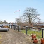 Terrasse mit Liege, Flagge und Blick auf Grünflächen