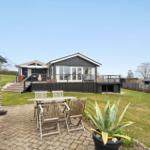 Haus mit Terrasse und Gartenbereich mit Tisch und Stühlen.