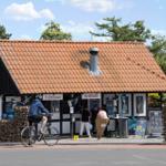 Kleines Haus mit rotem Dach und Verkaufsstand für Waffeln und Grillgerichte.
