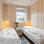 Zwei Betten in einem Zimmer mit Holzwänden und einem Fenster.