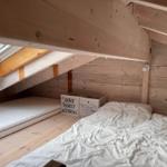 Dachgeschosszimmer mit Matratze, Bett und Fenster.