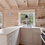 Küche mit Holzwänden, Arbeitsplatte und Fenster.