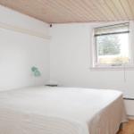 Schlafzimmer mit Bett, Fenster und Holzdecke.