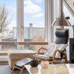 Ein Wohnzimmer mit Sessel, Kamin und großem Fenster. 