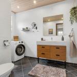 Badezimmer mit Waschmaschine, Waschtisch und Spiegel