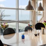 Esszimmer mit Blick aufs Meer und Blumenarrangement.