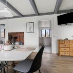 Esszimmer mit Tisch, Stühlen und Fernseher an der Wand