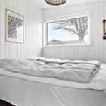 Schlafzimmer mit Bett, Fenster und Wanddekoration.