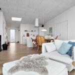 Wohn- und Essbereich mit Kamin, Sofa und Holzboden.