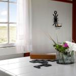 Tisch mit Blumen, Kerzen und Dominosteine vor Fenster mit Blick auf Grasland.