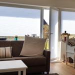 Wohnzimmer mit Sofa, Tisch und Fenster zur Terrasse.