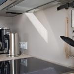 Küche mit Kaffeemaschine, Wasserkocher und Küchenutensilien.