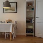 Essbereich mit Tisch, Stühlen und Bücherregal. Fernseher auf Holzschrank.