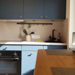 Küche mit blauen Schränken, Edelstahlgeräten und Holzoberfläche.