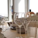 Gedeckter Tisch mit Gläsern und Schalen vor Fenster