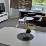 Wohnzimmer mit Essbereich, Sofa, TV und Balkon.