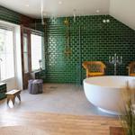 Bad mit grünen Fliesen, freistehender Badewanne und Dusche