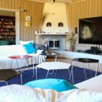 Wohnzimmer mit Sofa, Fernseher und Kamin. Bücherregal im Hintergrund.