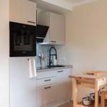 Küche mit integriertem Ofen, Spüle und Holztisch
