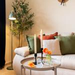 Ein Wohnzimmer mit einem Sofa, einem runden Tisch und einer Stehlampe.