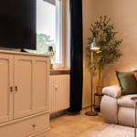 Wohnzimmer mit Sofa, Fernseher und Pflanze