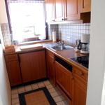 Küche mit Holzschränken, Spüle und Fenster