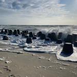 Wellen brechen an Steinen am Strand