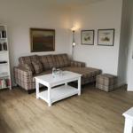 Wohnzimmer mit Sofa, Couchtisch und Bücherregal.