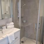 Badezimmer mit Dusche, Waschbecken und Spiegel