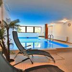 Innenpool mit Liegestühlen und Pflanze. Decke blau gestrichen.