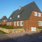 Rotes Backsteingebäude mit Dachfenstern und Steinmauer