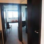 Flur mit Blick in Wohn- und Schlafzimmer mit Fenster und Sitzbank.