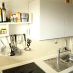 Küche mit Spüle, Kochfeld und Aufbewahrungsmöglichkeiten.