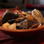 Eine Keramikschale mit Trockenfrüchten auf rotem Tischtuch.