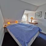 Schlafzimmer mit Bett, Nachttischen und Fenster