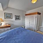 Schlafzimmer mit Bett, Kleiderschrank und Nachttisch unter Dachschrägen.