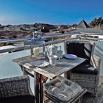 Terrasse mit Tisch, Stühlen und Blick auf die Landschaft.