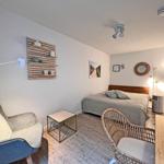 Schlafzimmer mit Bett, Sessel und Tisch. Wandregal und Wandspiegel sichtbar.