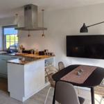 Küche mit Essbereich und Fernseher an der Wand