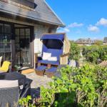 Terrasse mit Sitzgelegenheiten und Blick auf Leuchtturm