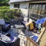 Terrasse mit Sitzgelegenheiten und Blick auf grünen Garten.