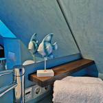 Badezimmer mit blauer Wand, Spiegel und Fischdekoration