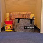 Wohnbereich mit Korb, Spielzeug und Aufbewahrungsbox.