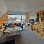 Wohnzimmer mit Sofa, Couch, Tisch und TV. Blick auf Balkon.