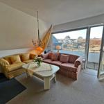 Wohnzimmer mit Sofa, Tisch und Blick auf Balkon