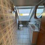 Badezimmer mit Dachfenster, Waschbecken und Toilette