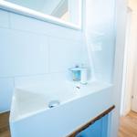 Waschbecken mit Spiegel und Seifenspender an Wand