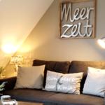 Ein Sofa mit Kissen unter einer Schrift an der Wand.