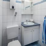 Badezimmer mit Toilette, Waschbecken und Spiegelschrank
