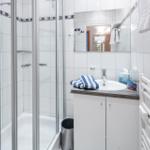 Badezimmer mit Dusche, Waschbecken und Handtuchheizung.